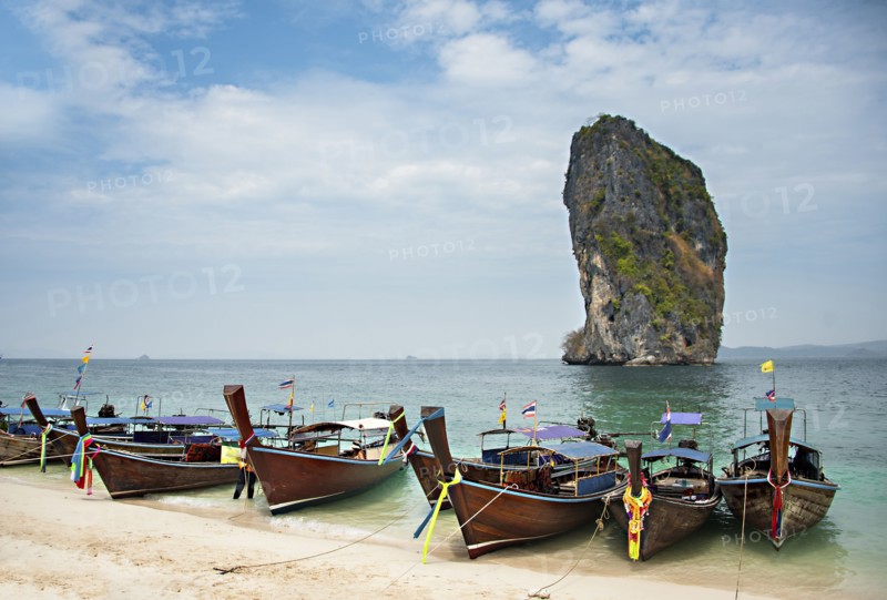 Canoes on sandy beach under cloudy sky