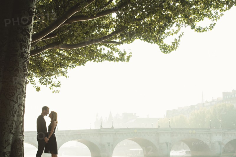Caucasian couple kissing near bridge
