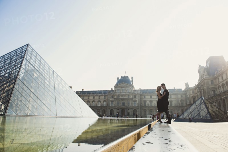 Caucasian couple kissing near ornate building