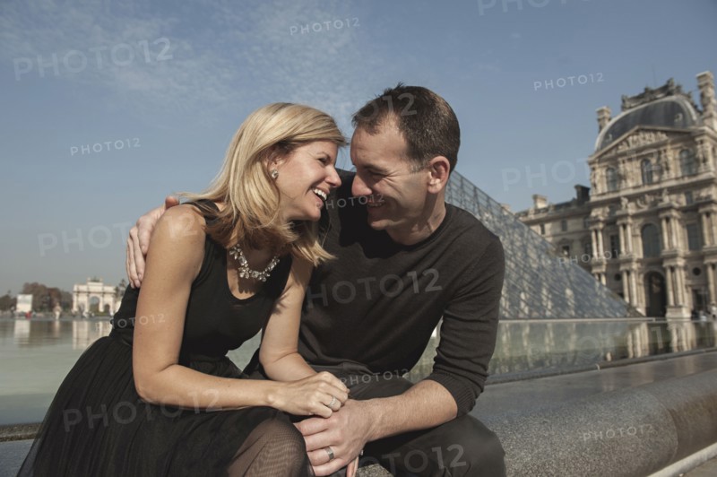 Caucasian couple laughing near fountain