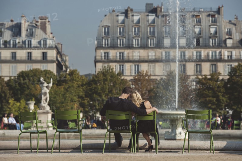 Caucasian couple admiring fountain in urban park