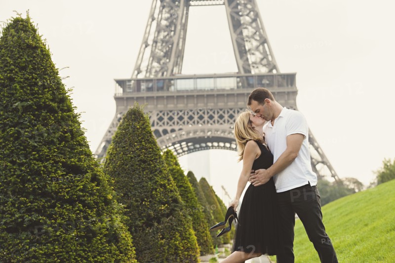 Caucasian couple kissing near Eiffel Tower