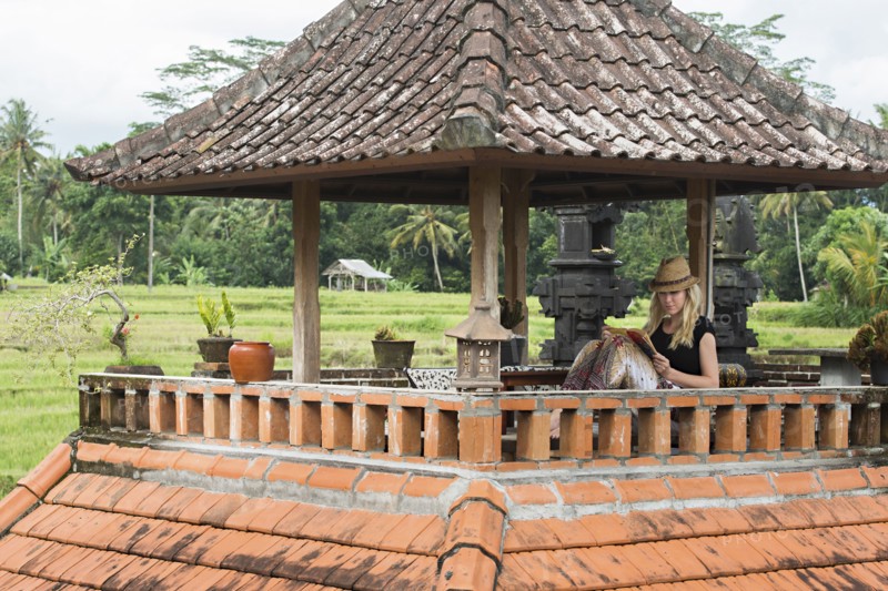 Caucasian woman reading book on rooftop balcony
