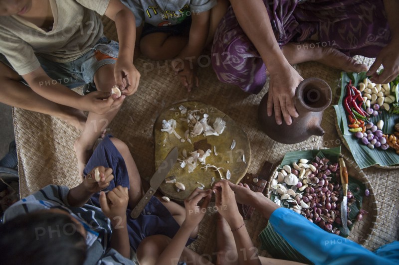 Asian family eating on woven mat