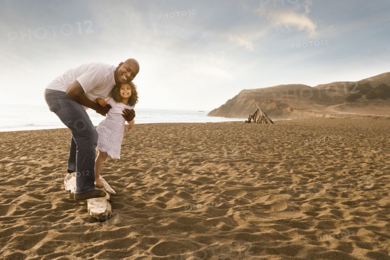 Father and daughter smiling on beach