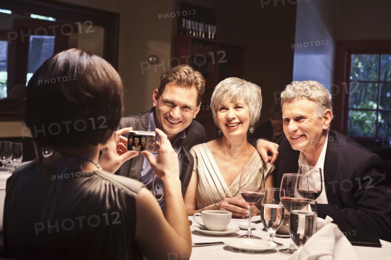 Woman photographing friends in restaurant