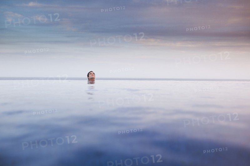 Hispanic woman soaking in swimming pool