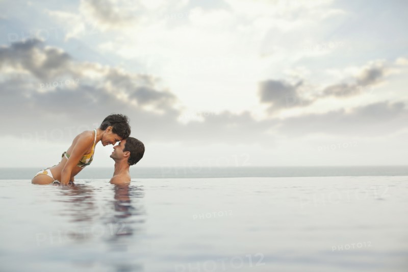 Hispanic couple enjoying swimming pool