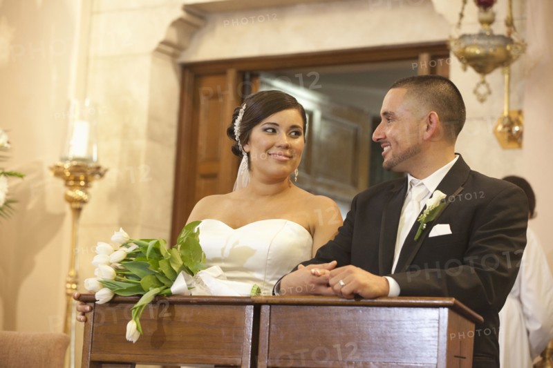 Hispanic bride and groom in wedding ceremony