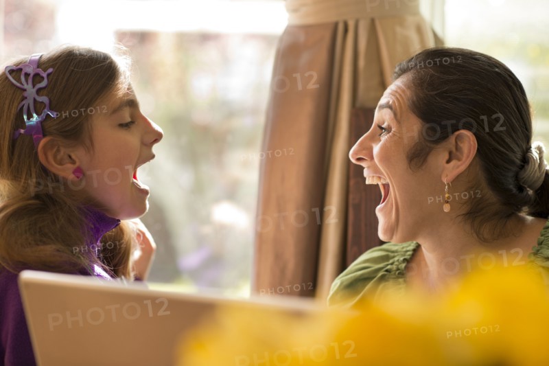 Mother and daughter talking at computer