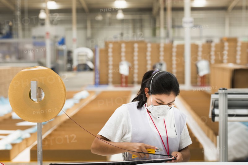 Worker wearing face mask in manufacturing plant