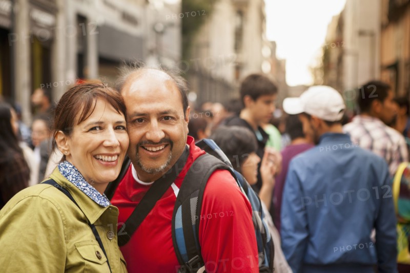 Hispanic couple smiling on city street