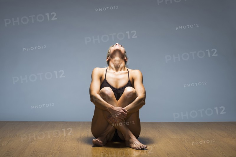 Caucasian woman practicing yoga in studio