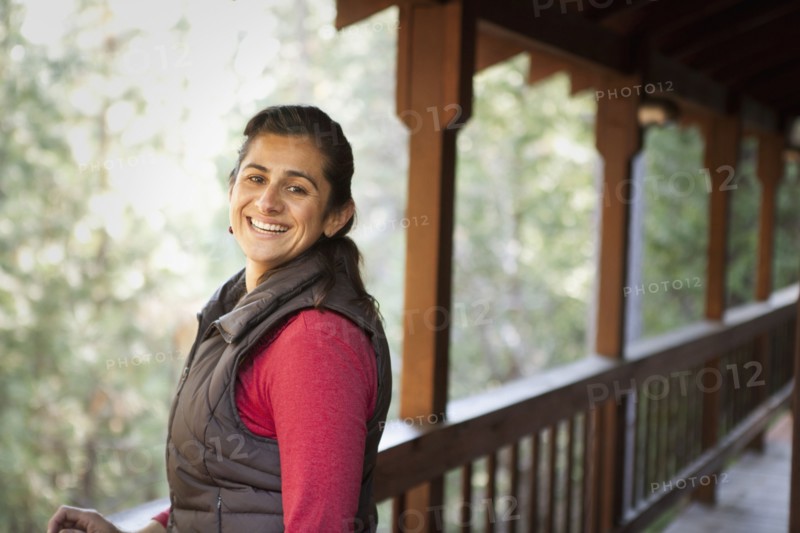 Hispanic woman smiling on porch