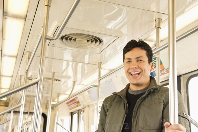 Hispanic man laughing on train
