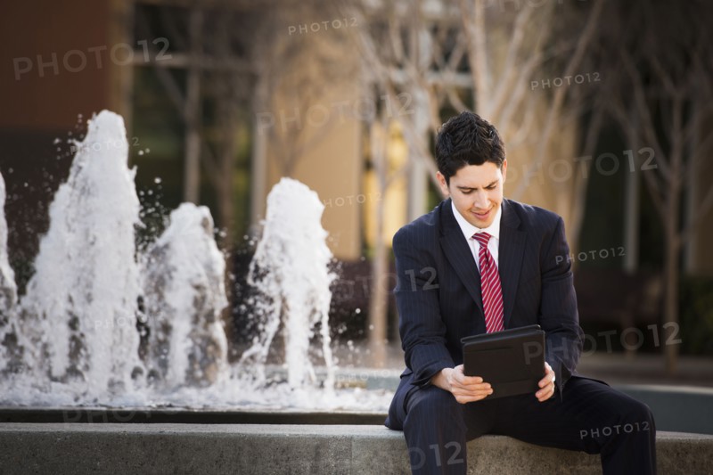 Hispanic businessman using tablet computer