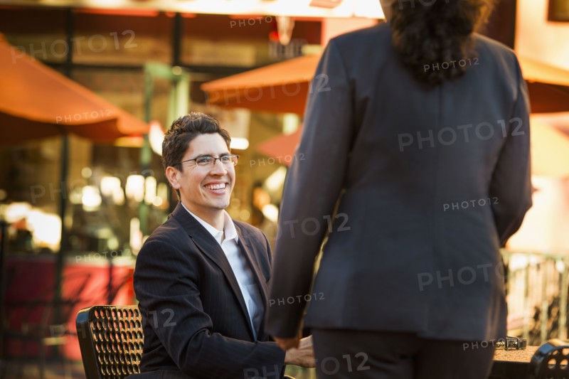 Hispanic business people working at cafe