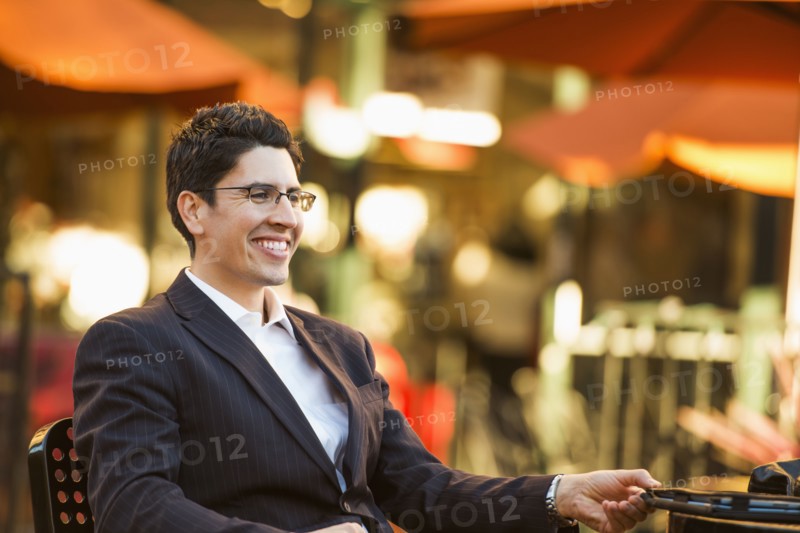 Hispanic businessman smiling at cafe
