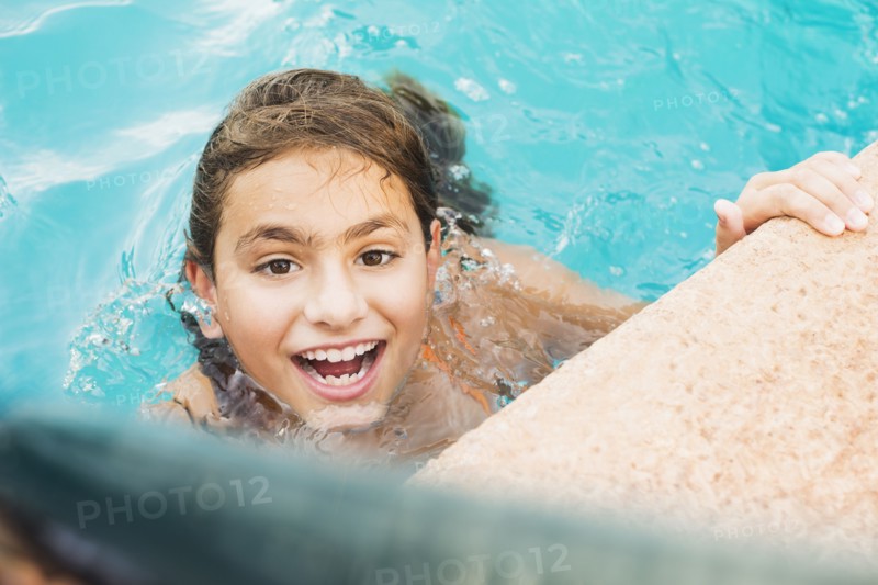Mixed race girl swimming in pool