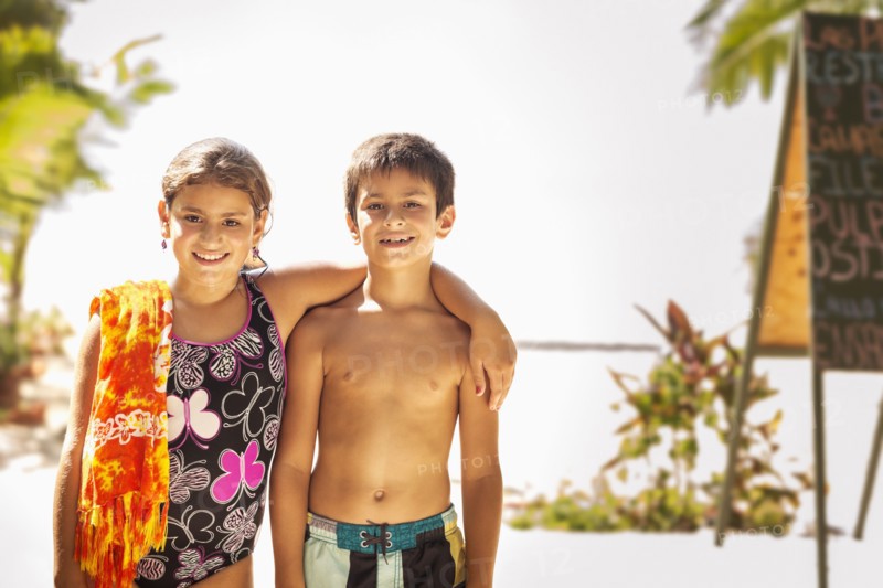 Mixed race children smiling on beach