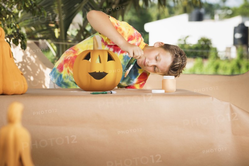 Caucasian boy decorating jack o'lantern