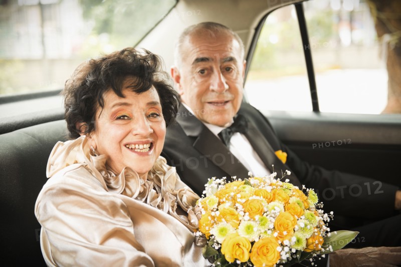 Senior newlywed couple riding in car