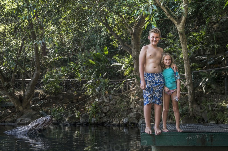 Caucasian children smiling by rural lake