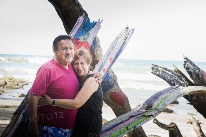 Hispanic couple hugging on beach