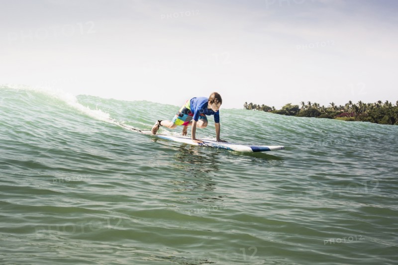 Caucasian boy surfing in ocean