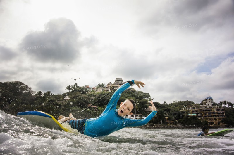 Boys surfing together in waves