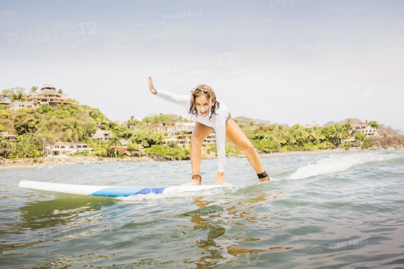 Mixed race girl surfing in waves