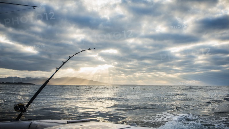 Fishing poles on boat over ocean waves
