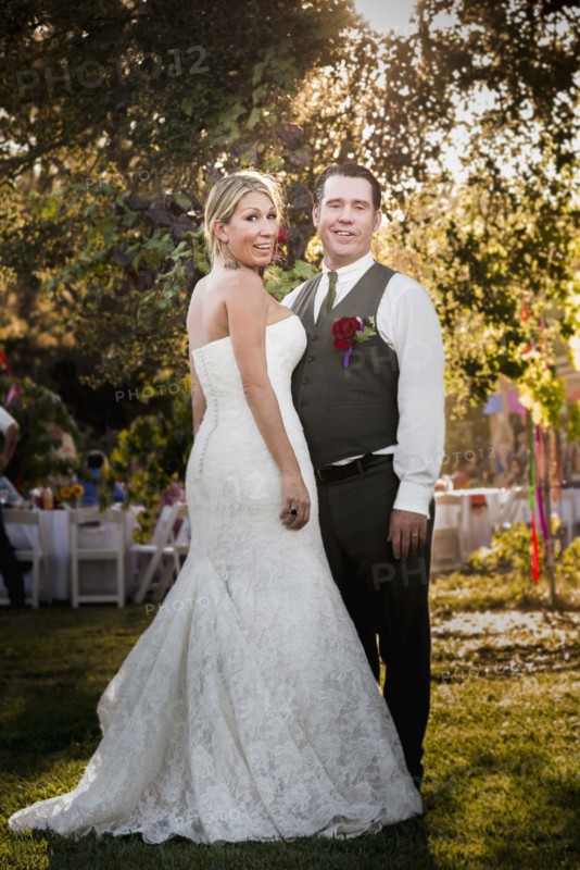 Caucasian bride and groom smiling at outdoor reception