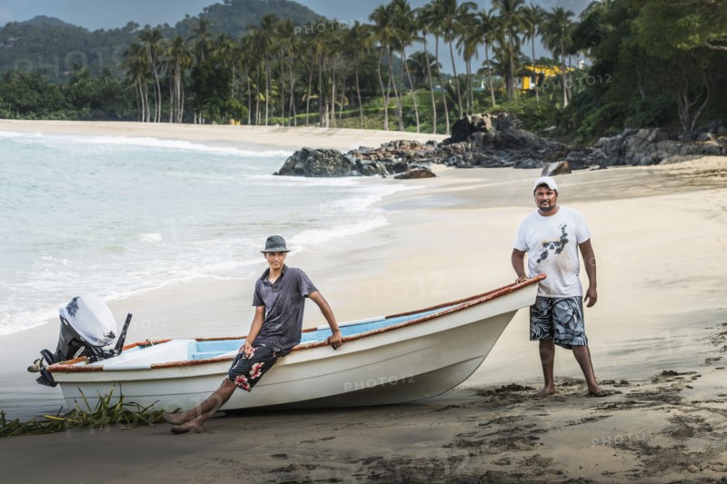 Friends standing near boat on beach