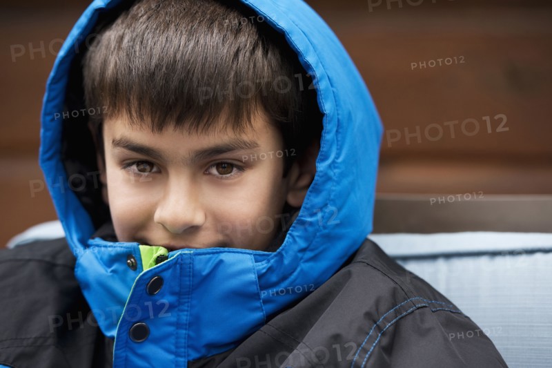 Close up of mixed race boy wearing parka and hood
