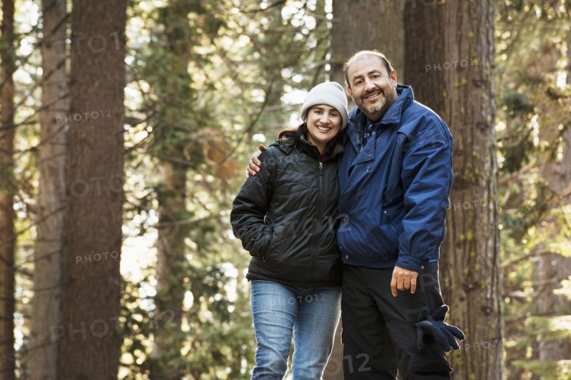 Hispanic couple hugging in forest