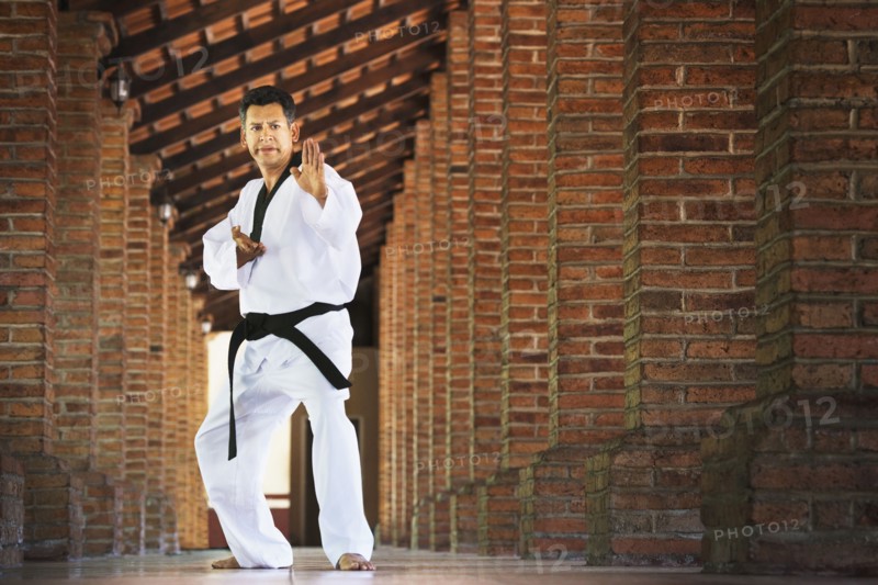 Hispanic man practicing martial arts in hallway