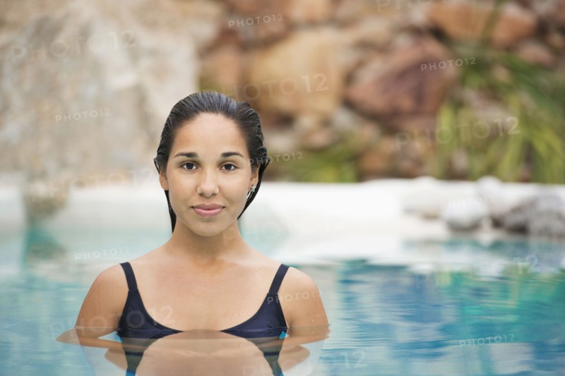 Hispanic woman swimming in pool