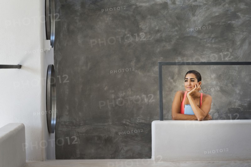 Hispanic woman sitting in modern living room