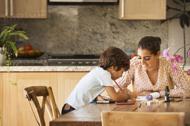 Hispanic mother and son playing game at table