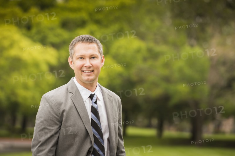 Caucasian businessman smiling in park