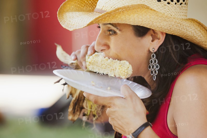 Close up of Hispanic woman eating corn
