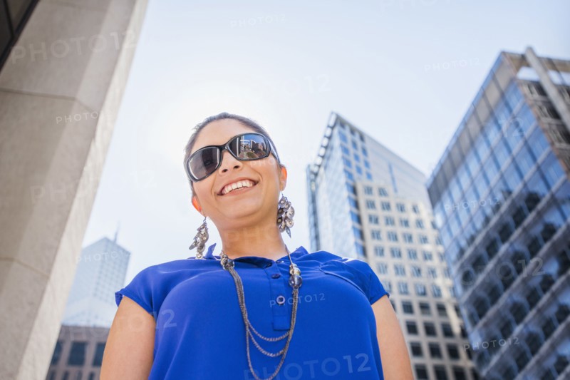 Hispanic woman walking under highrise buildings
