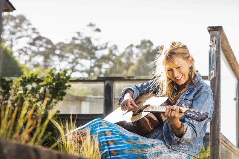 Caucasian woman playing guitar on porch