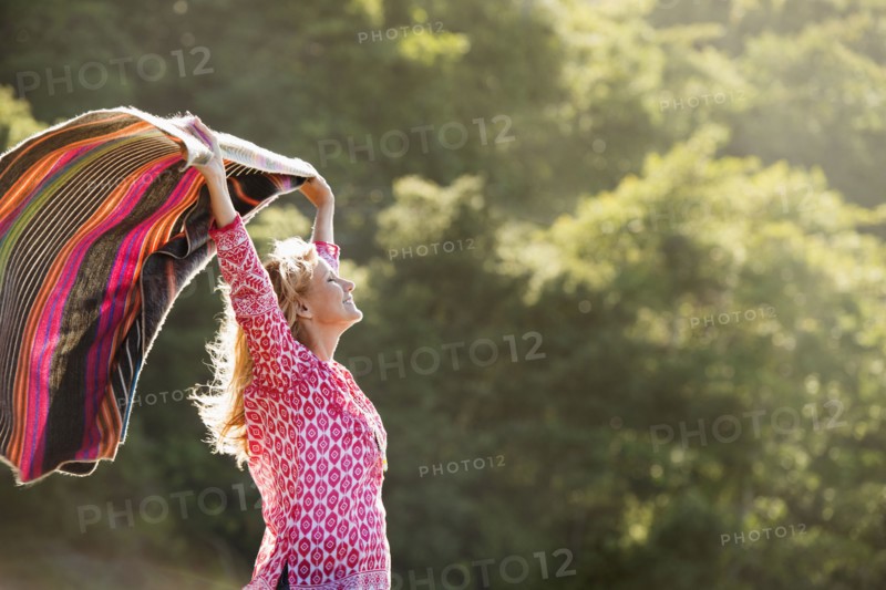 Caucasian woman holding blanket in wind