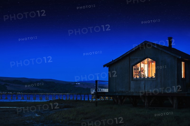 Glowing house and dock over remote lake