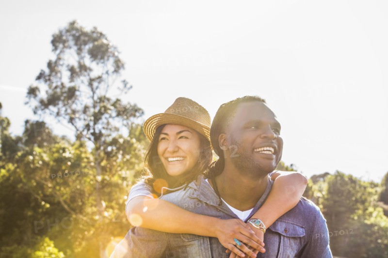 Man carrying girlfriend piggyback outdoors