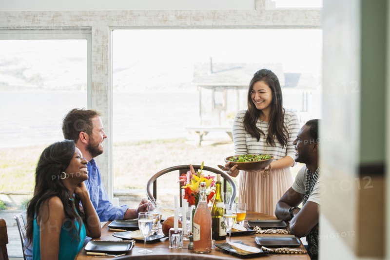 Woman serving friends at dinner party