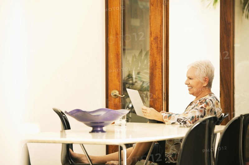 Woman using digital tablet at table