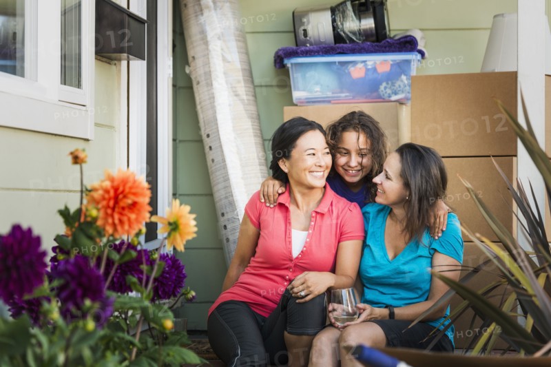 Family hugging outside house